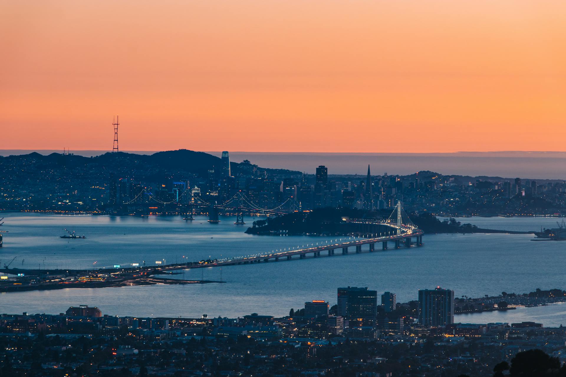 A breathtaking aerial view of the San Francisco skyline with Bay Bridge at sunset.
