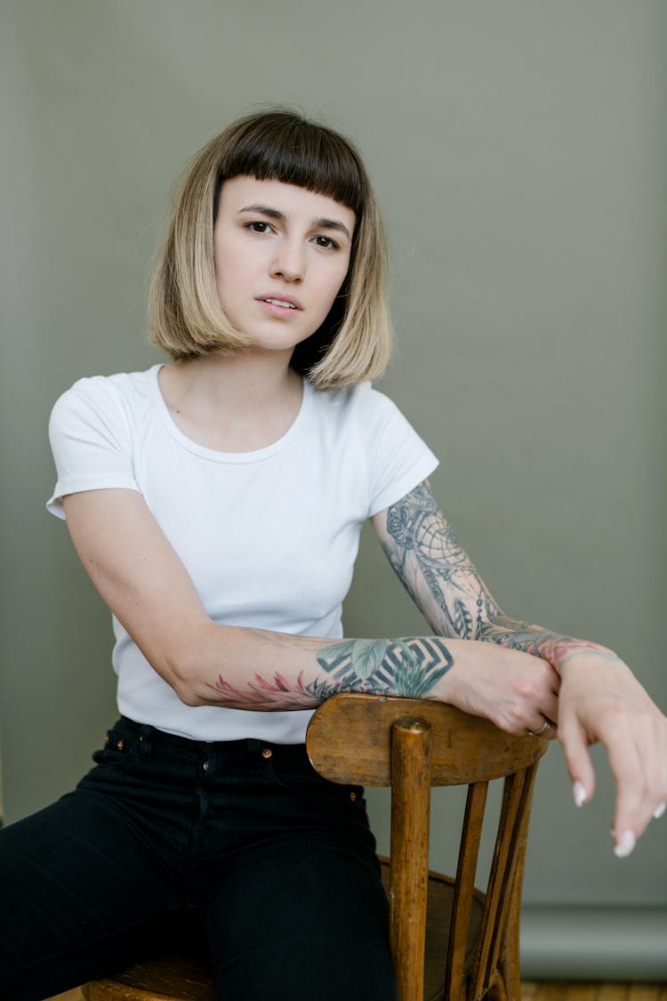 Confident Woman Sitting On Wooden Chair