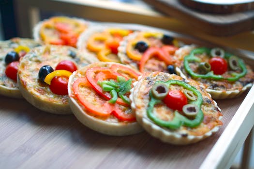 Close-up of homemade mini pizzas with vibrant vegetables, perfect for snacks.