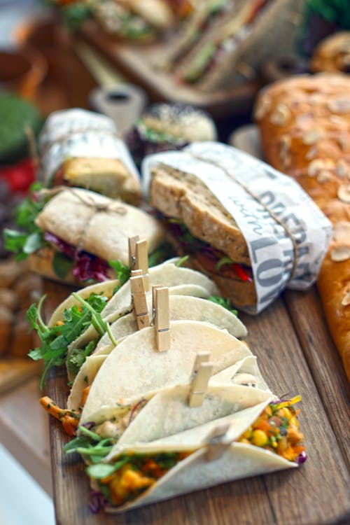 Sandwiches and Tacos on Wooden Board