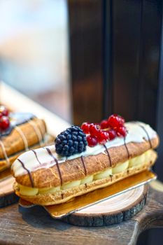 Gourmet eclairs topped with fresh berries perfect for dessert indulgence.