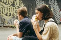 Woman in Black T-shirt Eating Bread