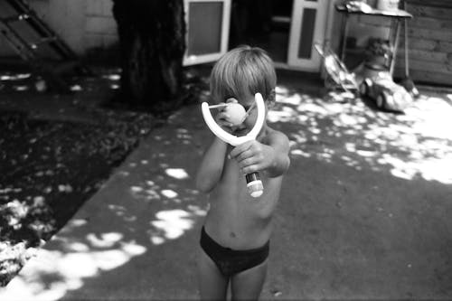 Grayscale Photo of Young Child holding a Toy 