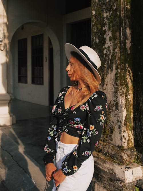 A Woman in Black Floral Crop Top Wearing Sun Hat while Looking Afar