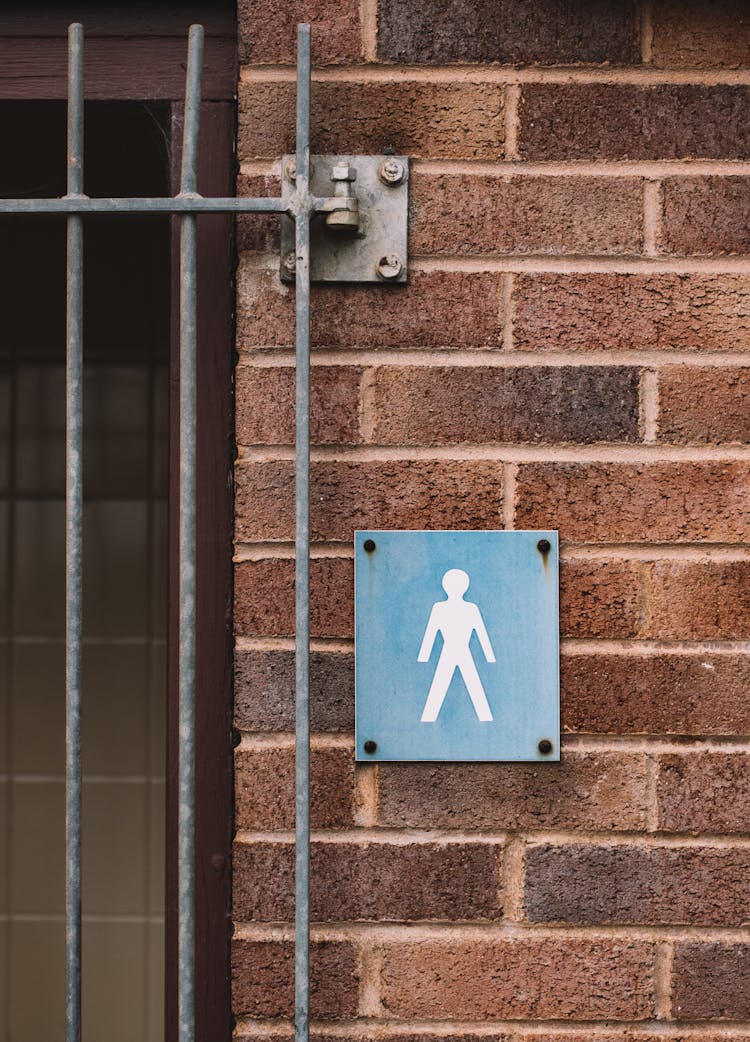 Metal Signboard With Person Image On Old House Wall