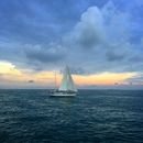 White Sailboat on Sea Under White Clouds