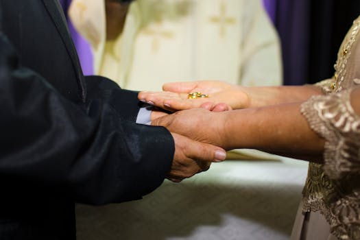 Close-up of bride and groom exchanging rings during an elegant wedding ceremony indoors.