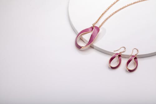 Free A Pair of Earrings and Necklace on a White Surface Stock Photo