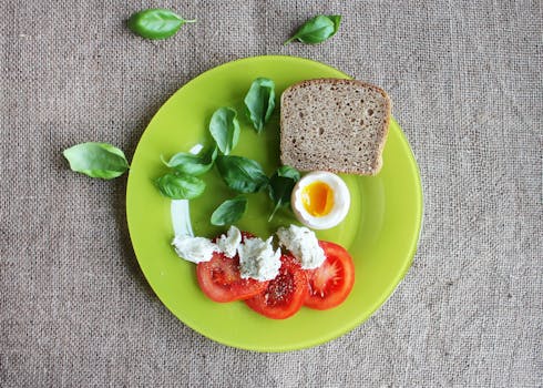 早餐盘的俯视图，包括面包、煮鸡蛋、西红柿和罗勒