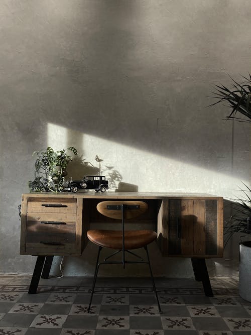 Brown Wooden Desk With Chair Near the Wall