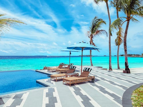 Lounge Chairs by Infinity Pool on Tropical Beach
