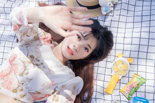Free Young woman in floral dress relaxing outdoor on a sunny day, capturing a moment of leisure. Stock Photo