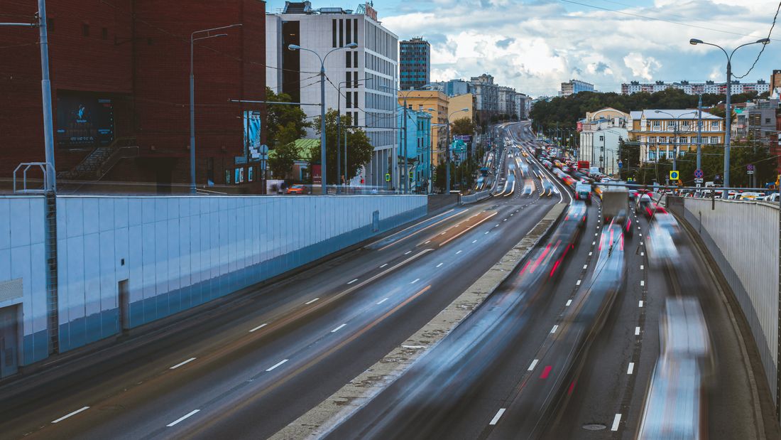 Motion-blurred traffic on a city road in daylight — photo by 84LENS on Pexels