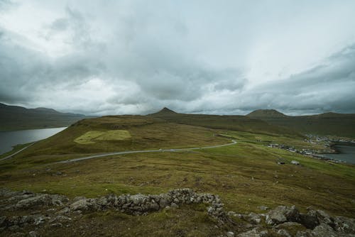 Green Grass Field Under Cloudy Sky