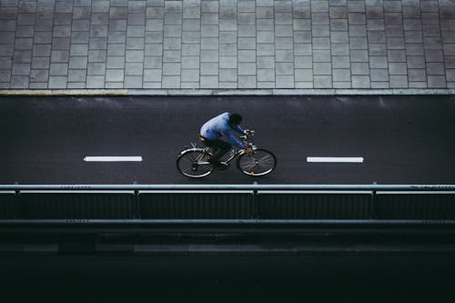 Top View Shot of a Man Riding on a Bicycle while Moving on the Road