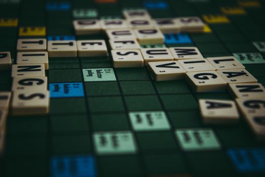 Close-up of a Scrabble board with words formed using tiles, showcasing strategic gameplay.