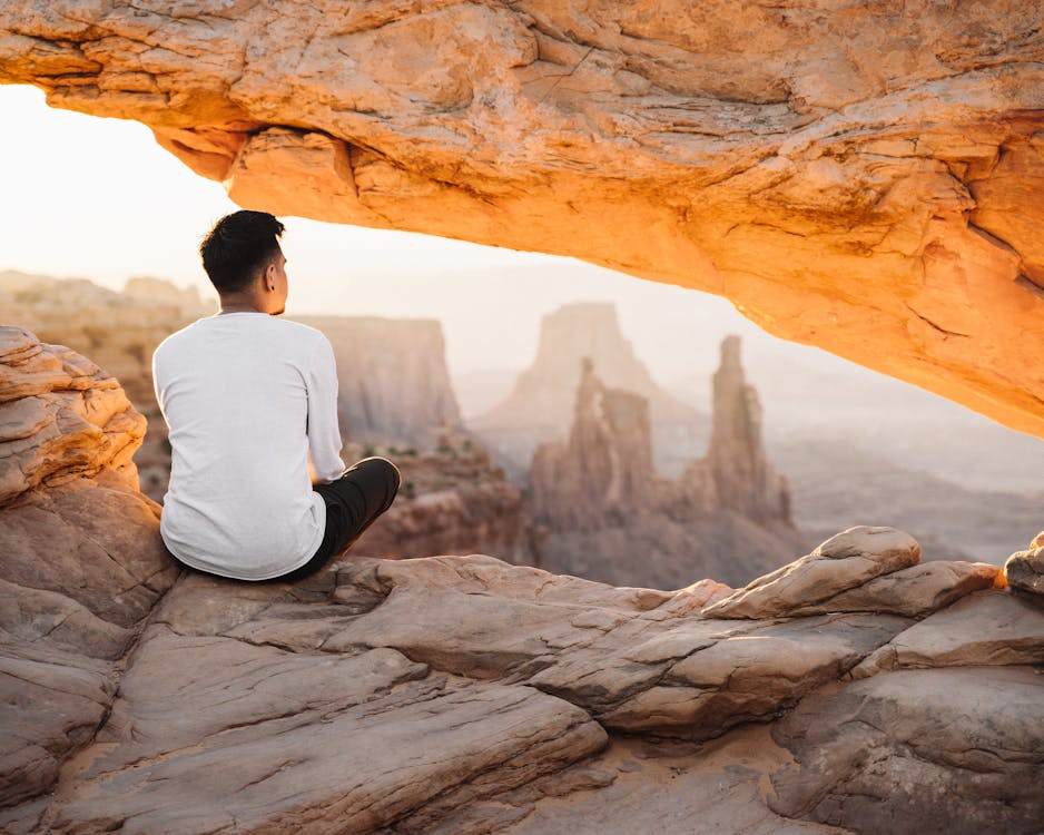 Free Back View of a Man Sitting on Cliff Stock Photo