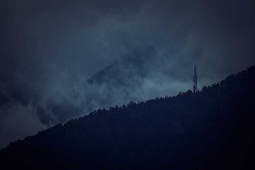 Gloomy dark sky above hilly terrain at night