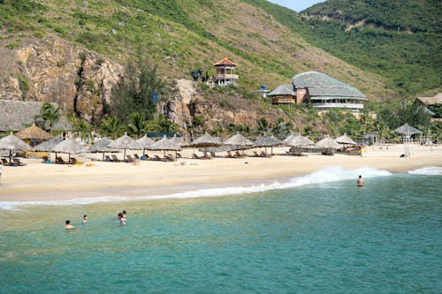 Sandy beach with chilling people on hilly terrain