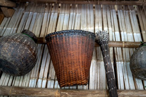 Wicker basket and vase on shabby wooden surface