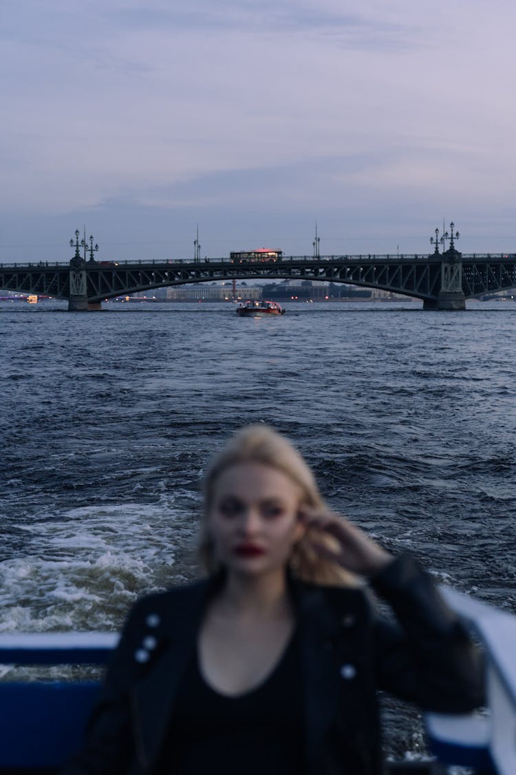 A Woman In Black Leather Jacket Sitting On A Sailing Motorboat 