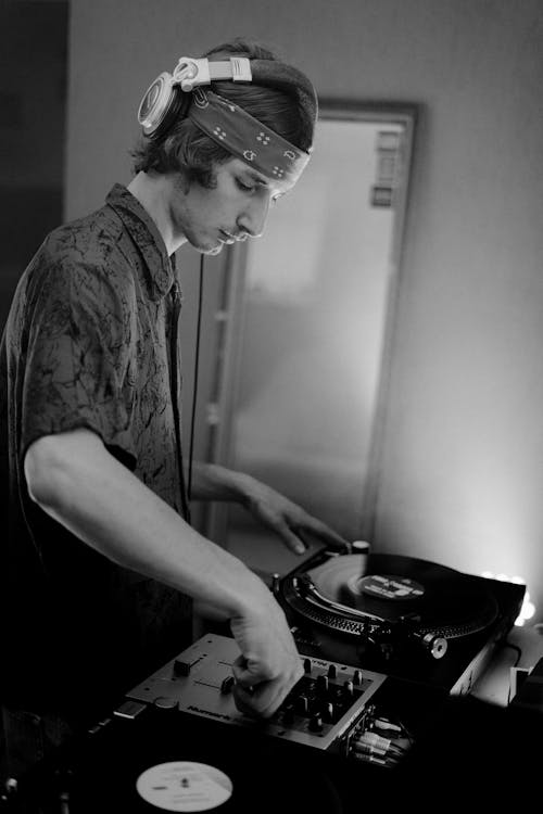 Monochrome Photo of Man using a Vintage Tunrtable 