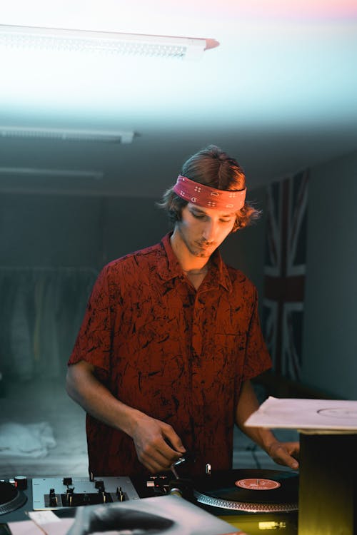 Man in Brown Polo using a Vinyl Record Player 