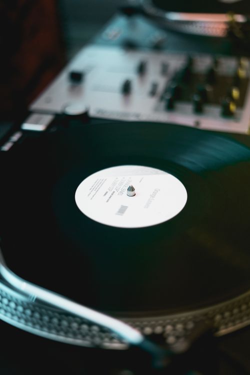 Free Close-up of a classic turntable spinning a vinyl record on wood surface. Stock Photo
