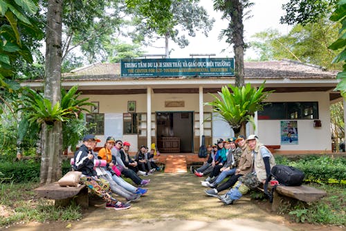 Group of Asian tourists sitting on benches before hiking