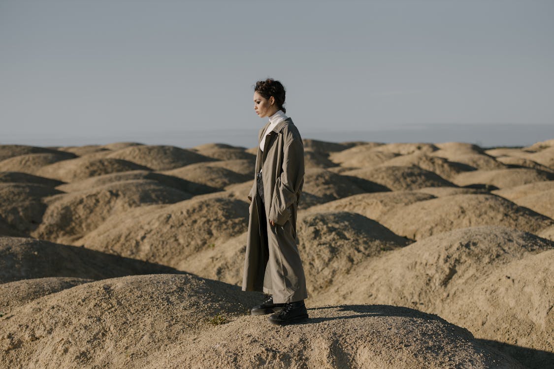 Free Man in Brown Coat Standing on Brown Sand Stock Photo