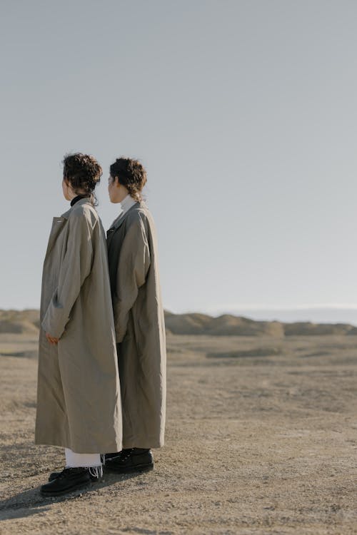 Man in White Coat Standing on Brown Field