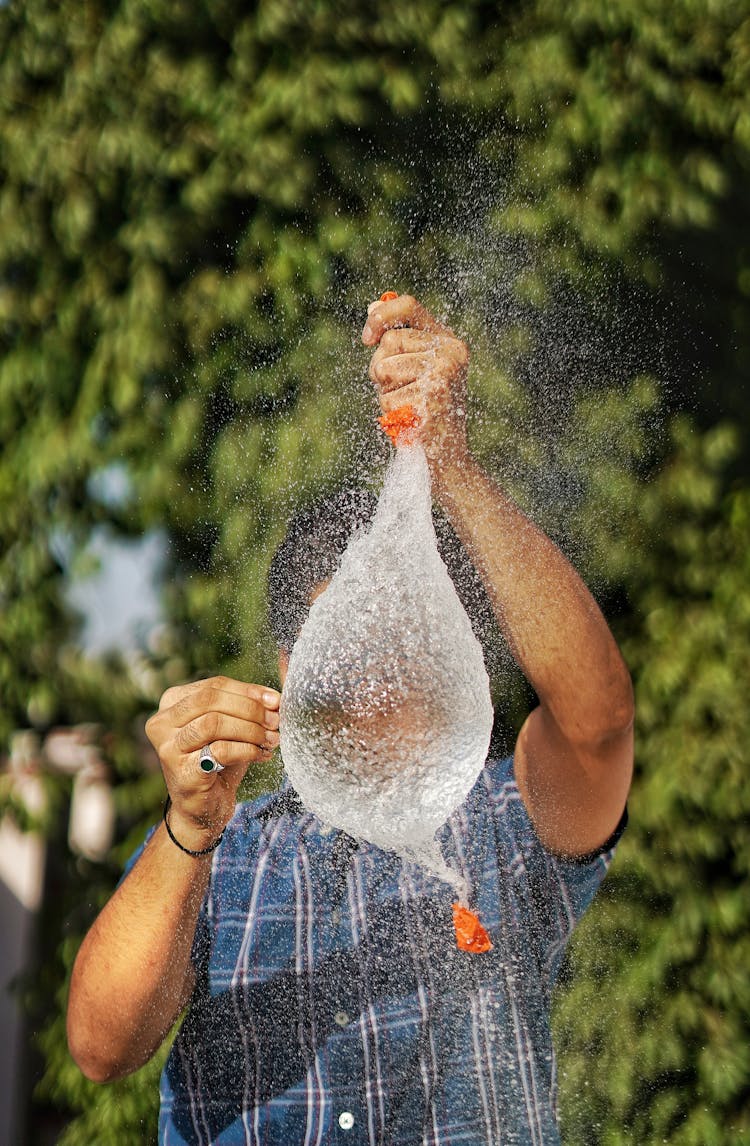 A Man Popping A Water Balloon