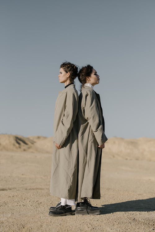 Woman in Gray Long Sleeve Dress Standing on Brown Sand