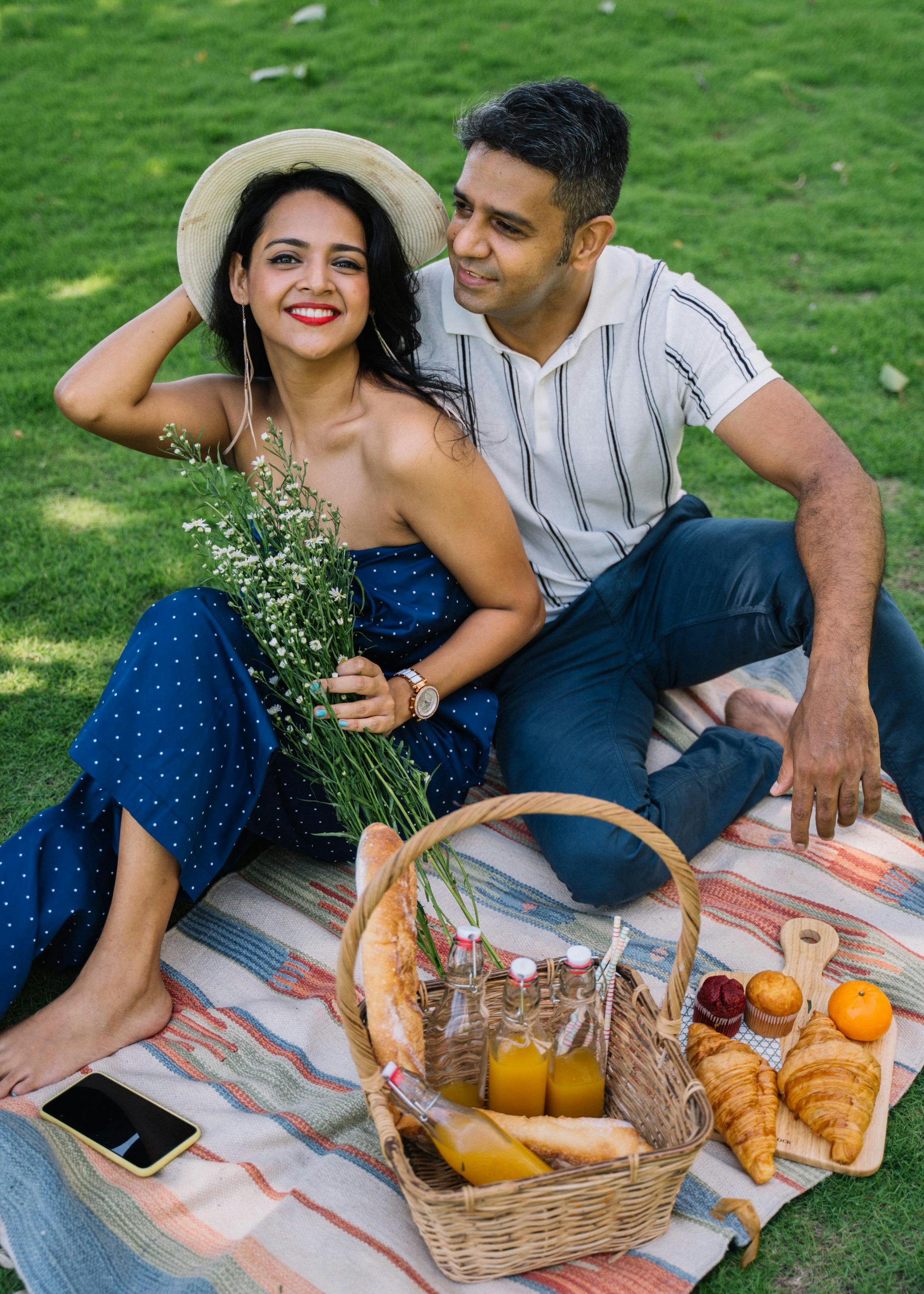 man and woman sitting on a picnic mat