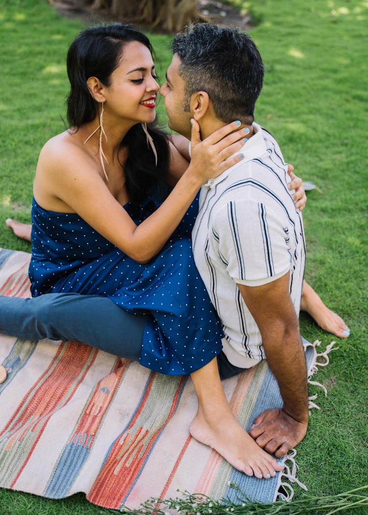 A Couple Kissing On A Picnic Mat