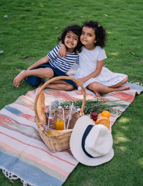 Free Two Little Girls Sitting on Picnic Blanket Stock Photo