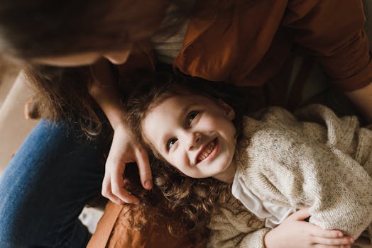 一张温馨的照片中，一个孩子微笑着在室内与父母建立了联系