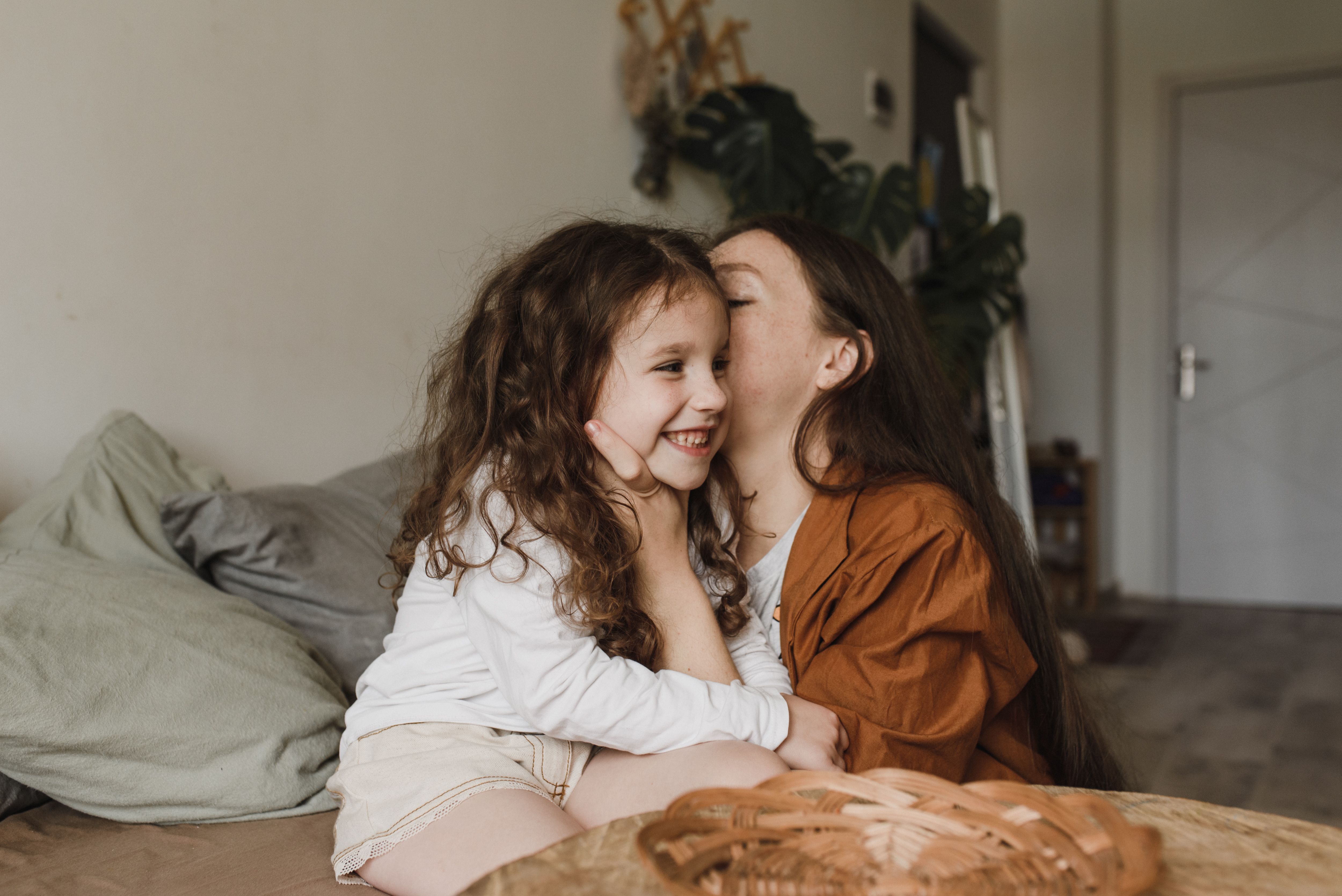 A mother kissing her little daughter