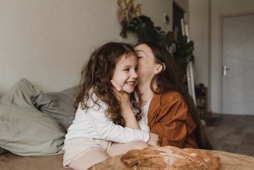 Young Woman kissing her Sibling 