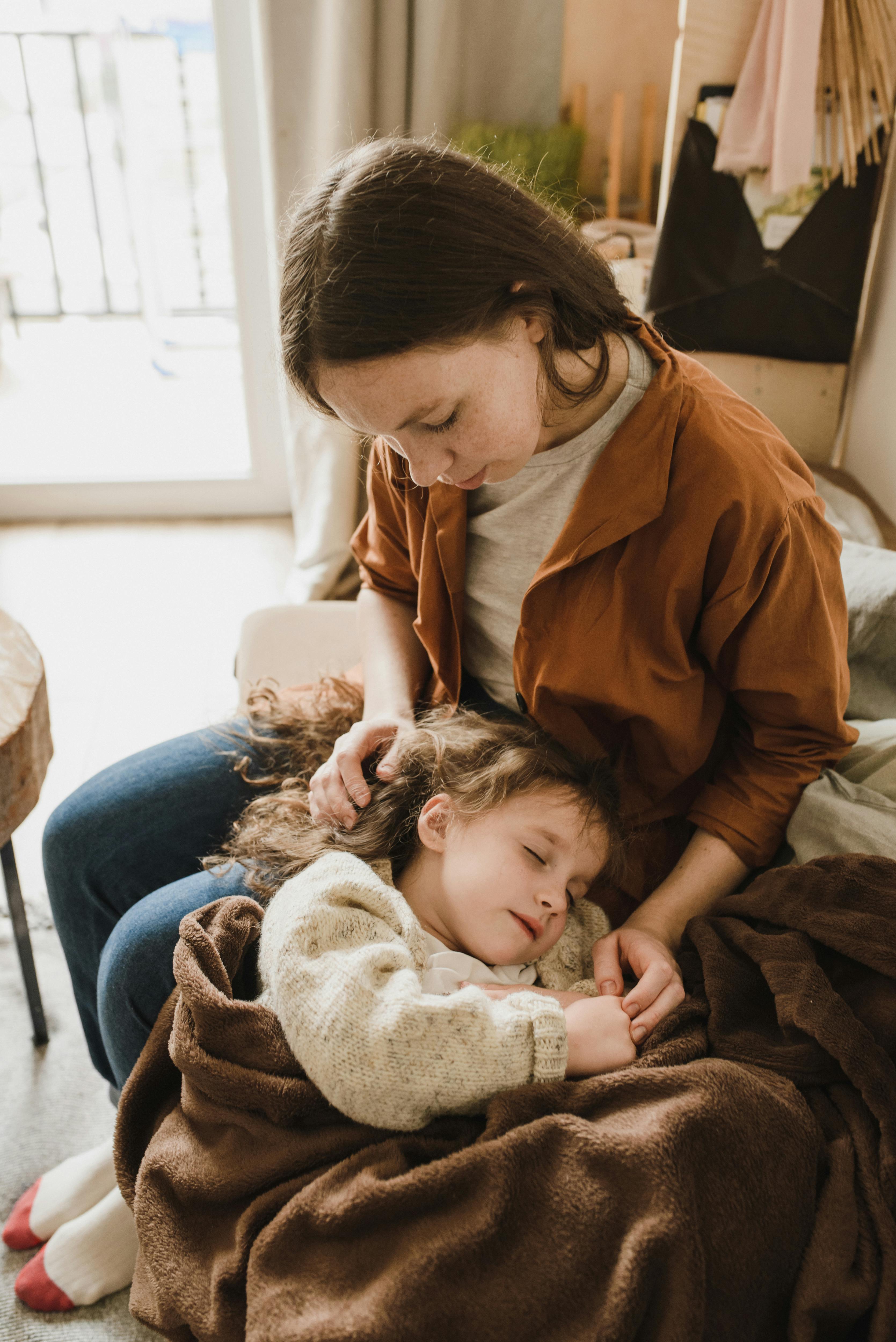 a girl sleeping on a woman s lap