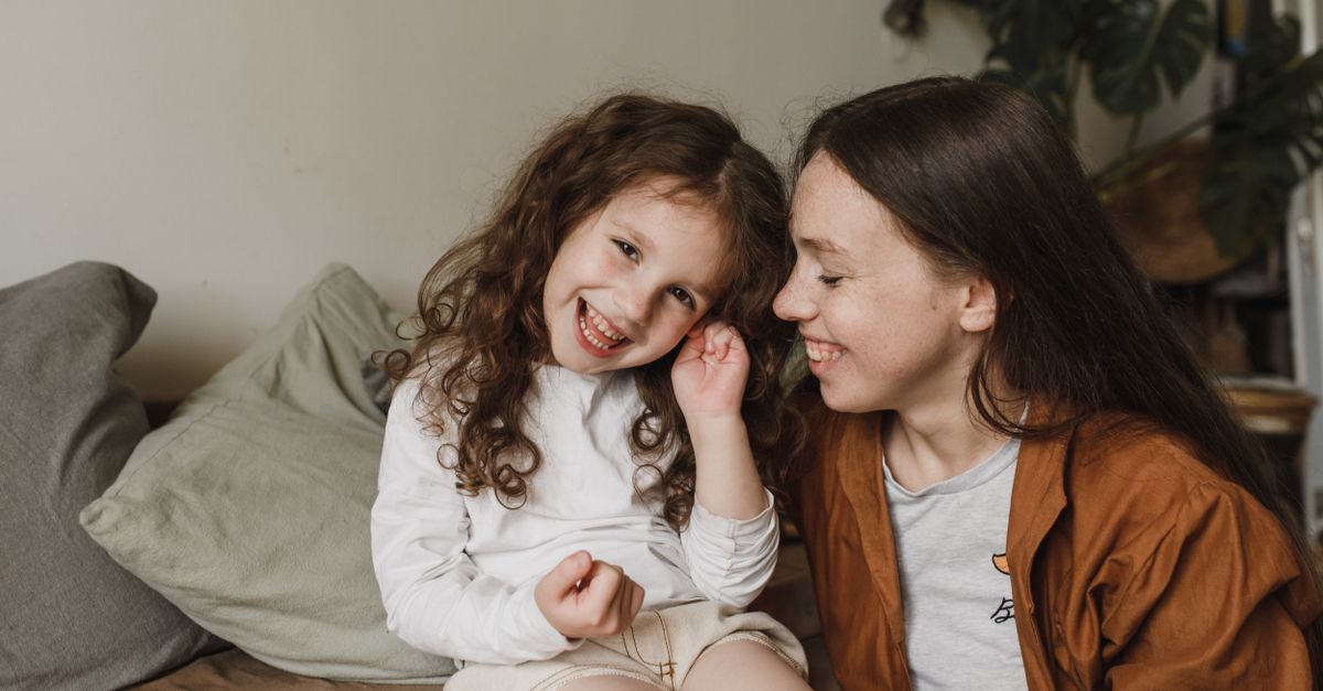 Une mère et sa fille heureuses profitant d'un moment tendre à l'intérieur, échangeant des sourires.