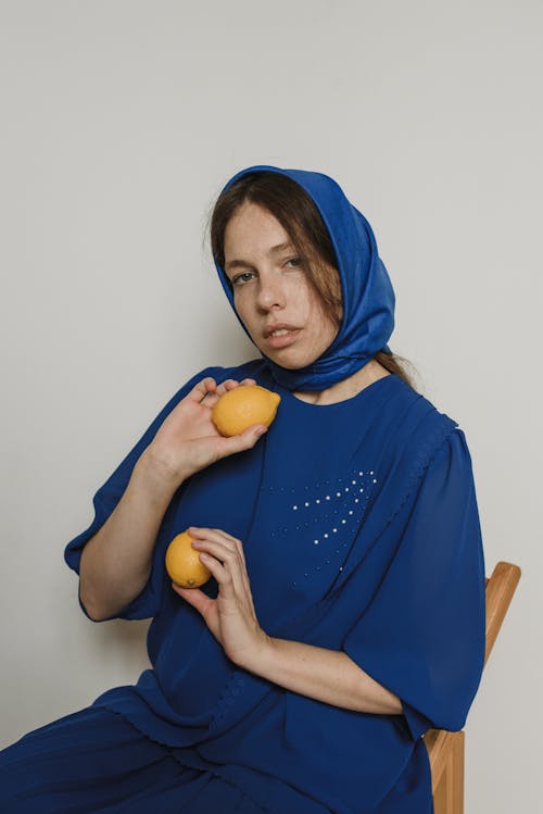Woman Wearing Blue Headscarf Holding Lemons