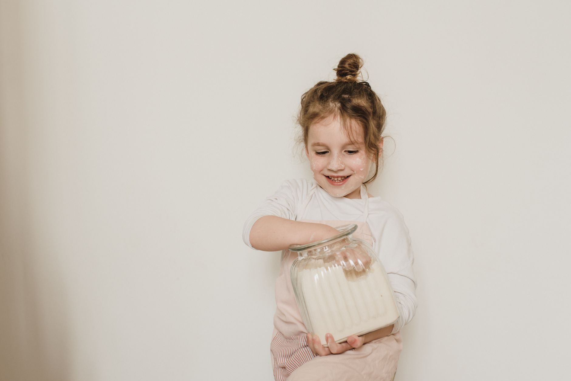 Happy young girl enjoying marshmallows from a jar. Perfect for lifestyle and family themes.