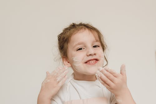 Free Child Putting Powder on Her Face Stock Photo