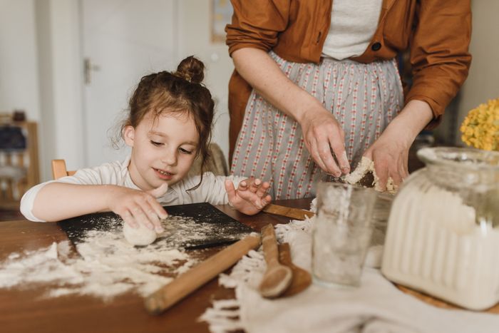 Little baker kneading dough with focus and joy