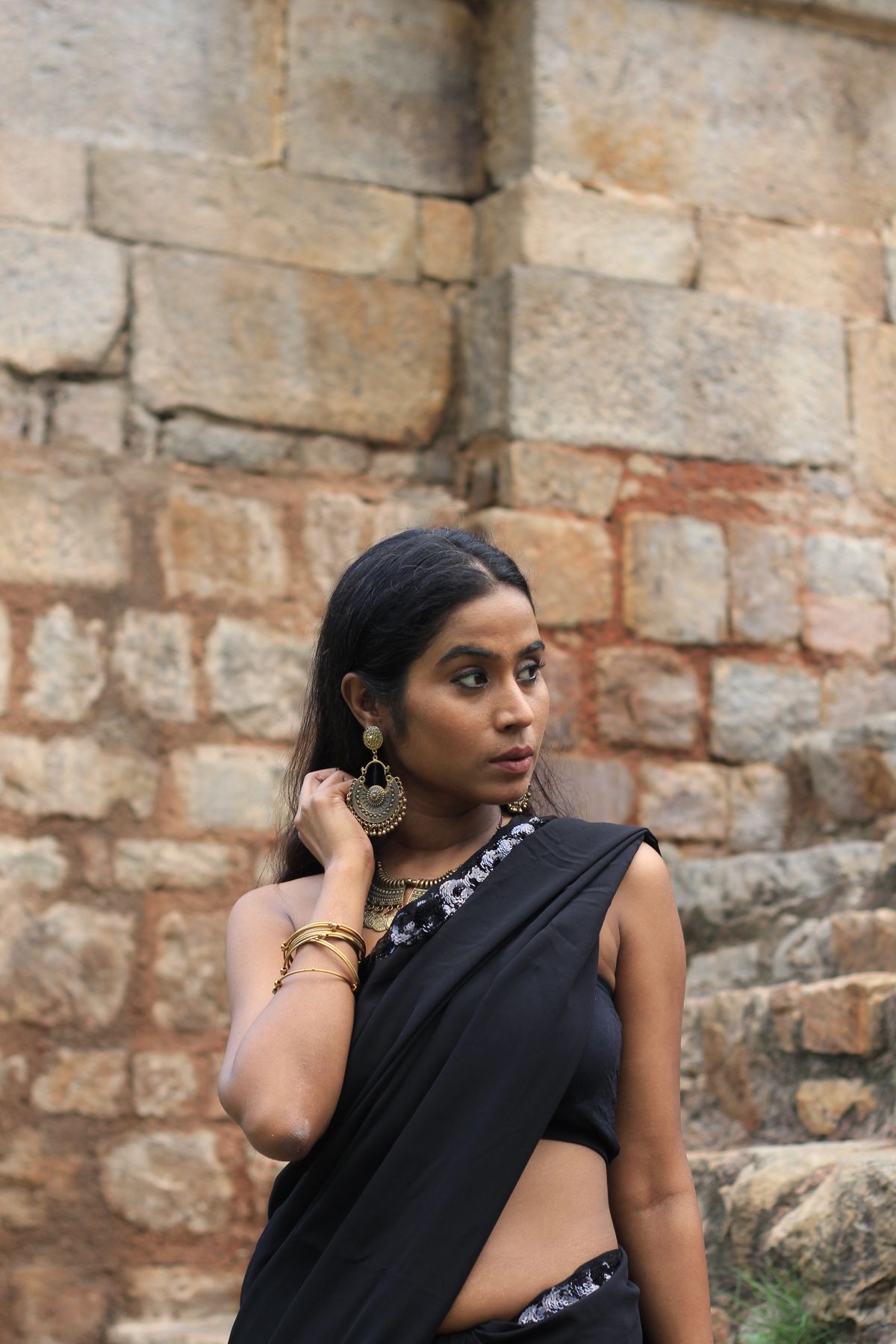 Elegant model wearing black saree with traditional statement jewellery