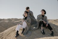 时尚团体身着风衣，在宁静的沙漠中摆姿势