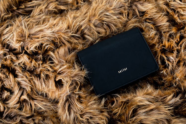 Black Purse On Brown Fur Textile