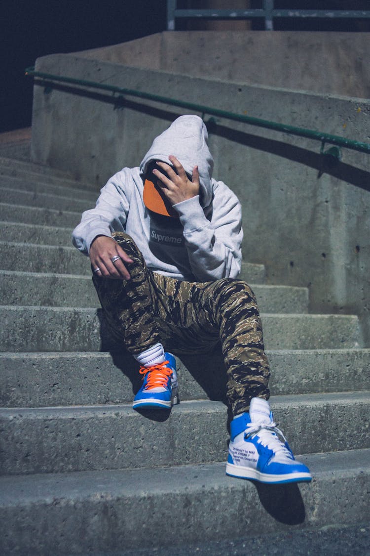 Unrecognizable Stylish Man In Luxury Sneakers Resting On Stairs