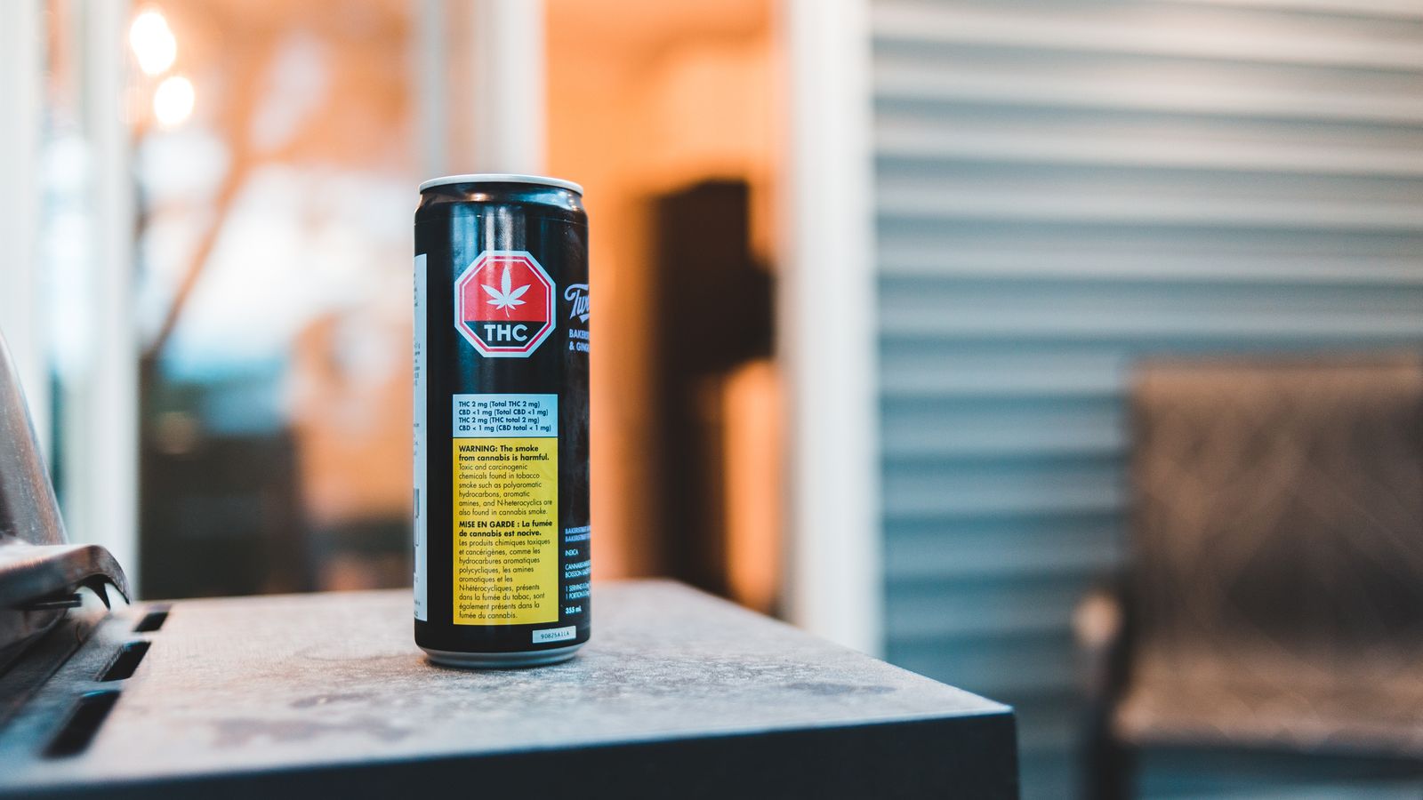 Colorful can of cannabis drink with text and image on shiny surface in building